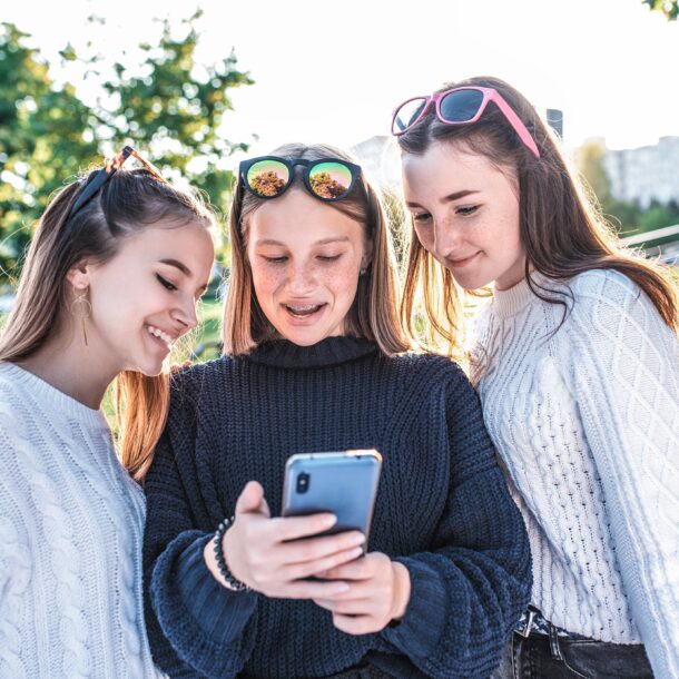 Three girls playing on a phone together