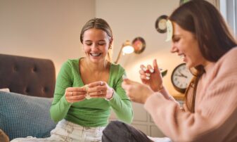 Two female friends playing a card game