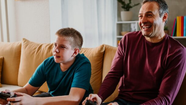 Male support worker and boy playing a games console