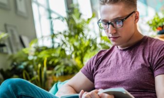 Young male adult reading a book