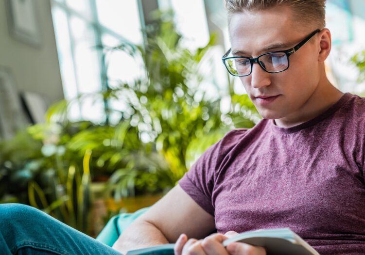 Young male adult reading a book